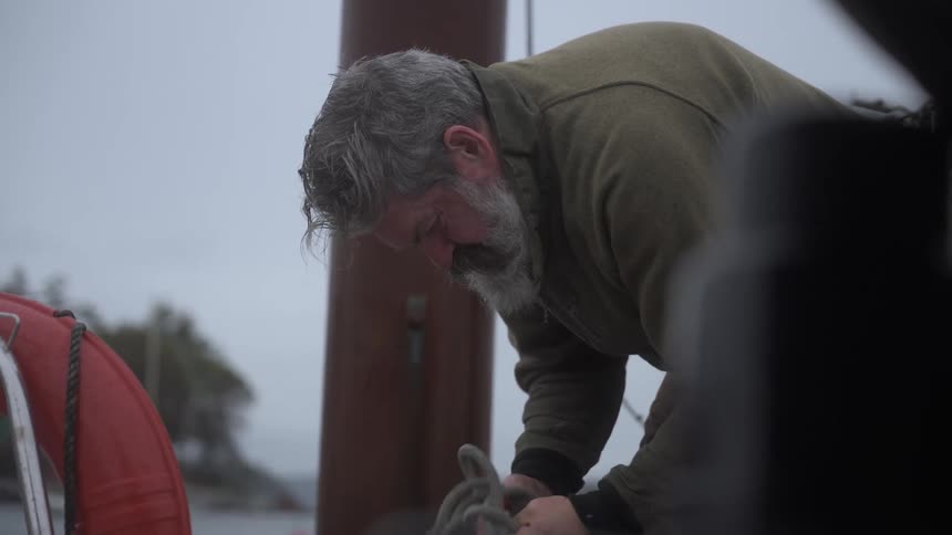 White bearded man tying a rope