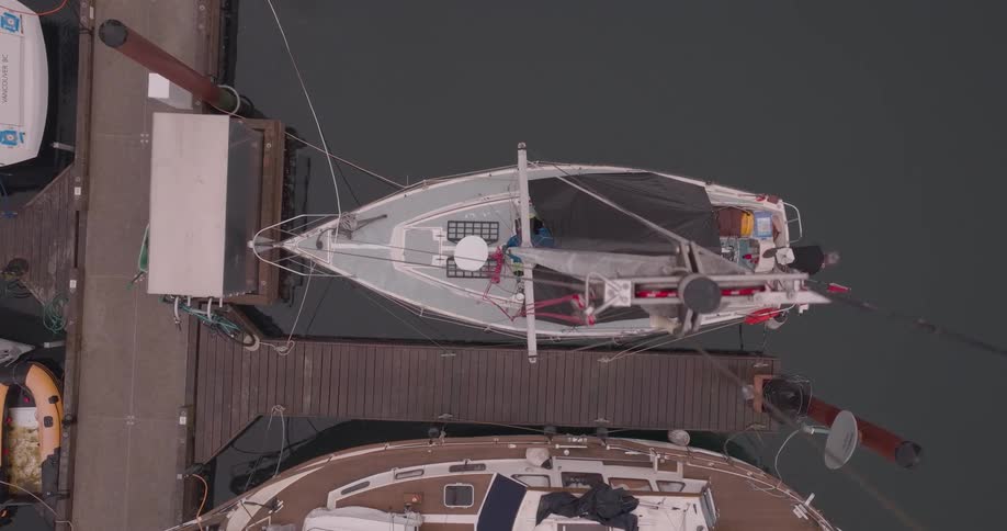 Birds eye view of sailboat bobbing back and forth while docked in the harbor