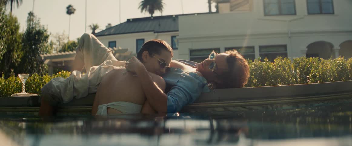 A man rubs a womans head in the pool
