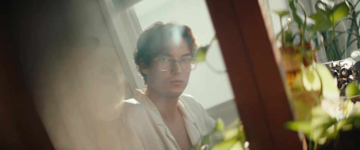 A man turns his head to look out the window