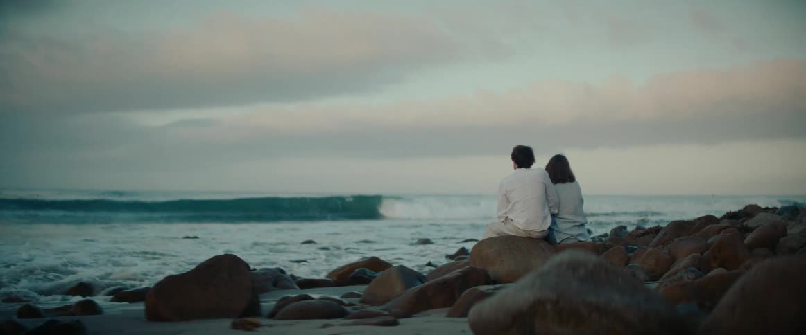 A footage of a couple sitting by the shore