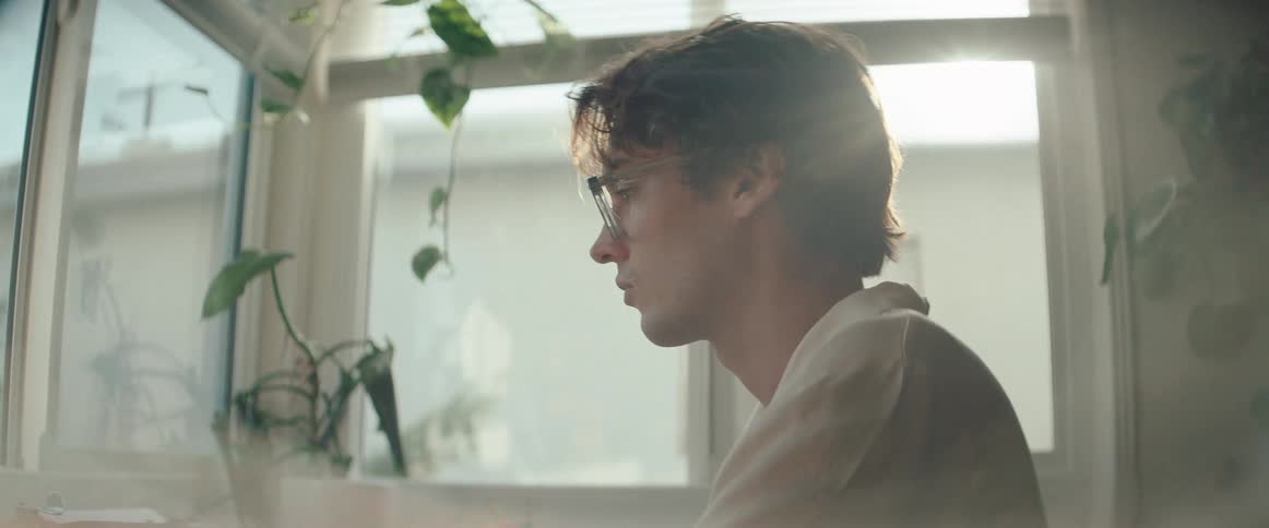 Side portrait of a man wearing glasses in an indoor space