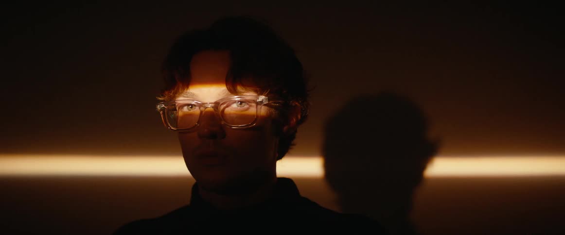 Man with glasses and a beam of light in his face