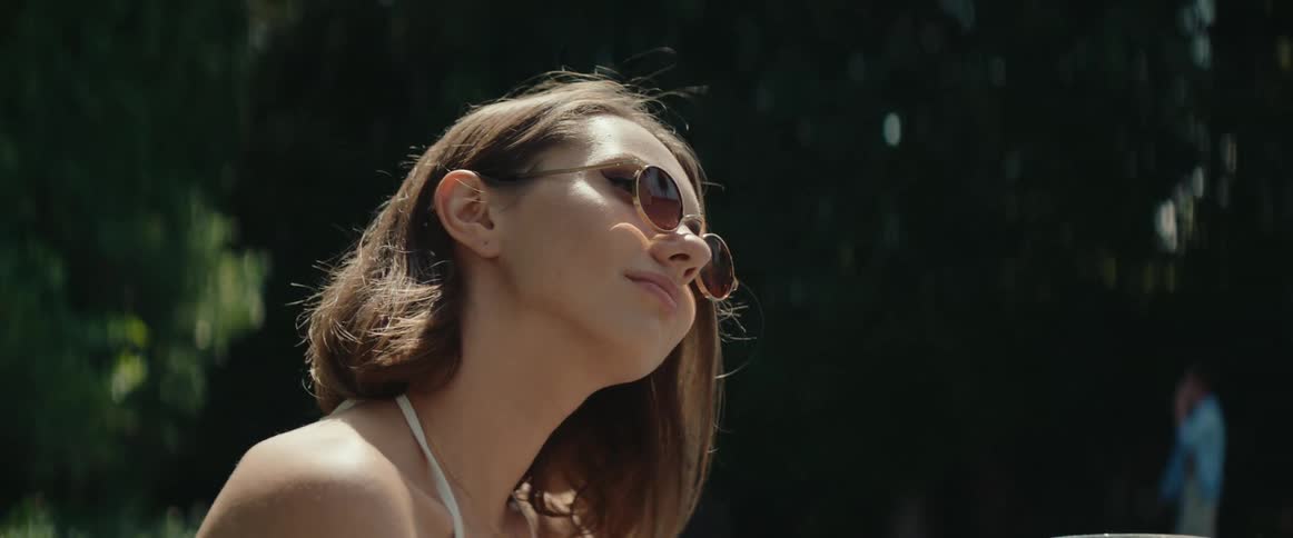 Woman wearing sunglasses sitting outdoors