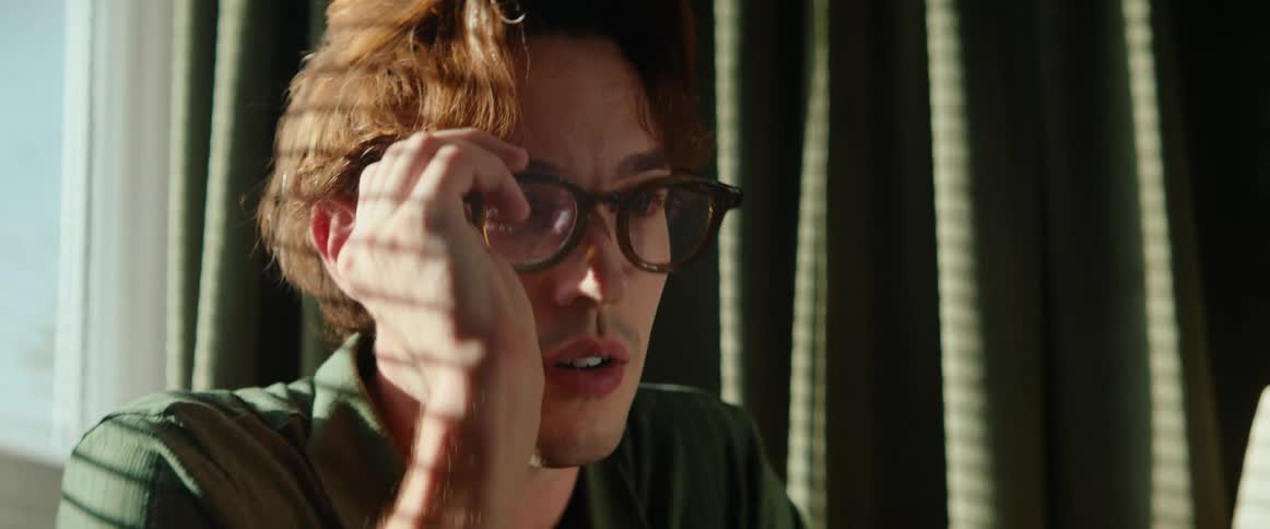 Thoughtful man putting on prescription glasses