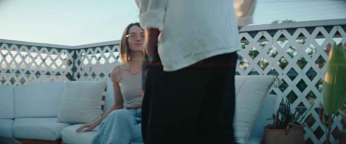Man sitting next to a woman on a white sofa outdoors