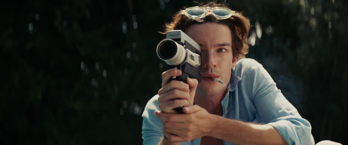 Man smoking outdoors and using a vintage camera