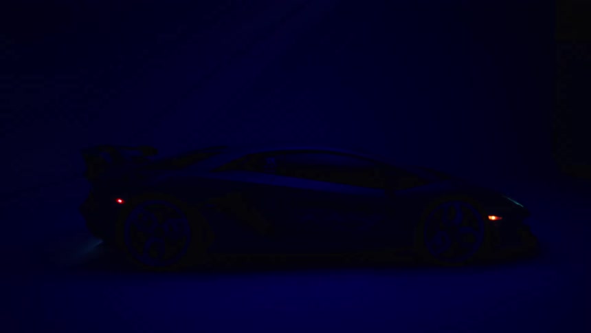 A sleek dark sports car with illuminated orange lights is silhouetted against a deep blue backdrop