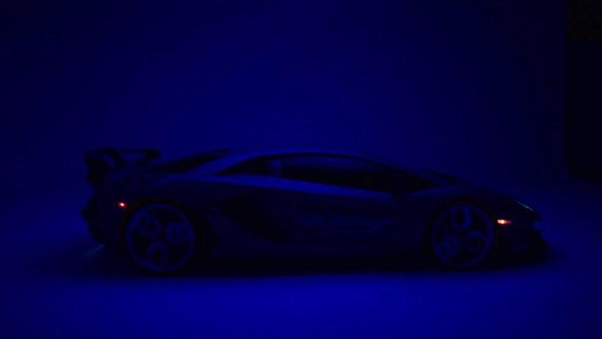 A lamborghini is on display using a blue flashing light
