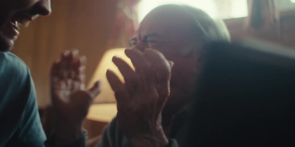 Elderly man next to another young man vibrating happily