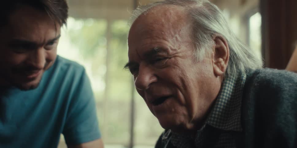 Elderly man and young man looking in the same direction happily