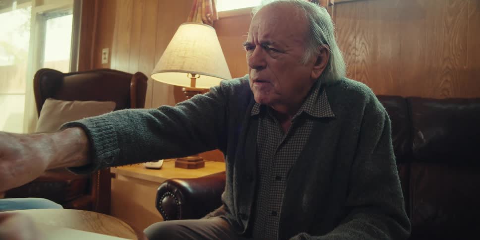 Elderly man interacting with a nurse in a living room