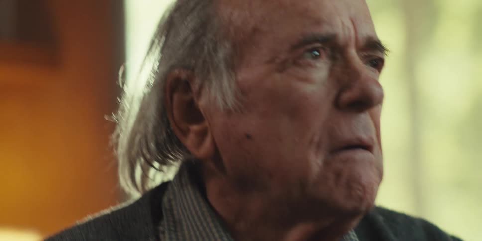 An elderly man looks very upset as he talks to another man