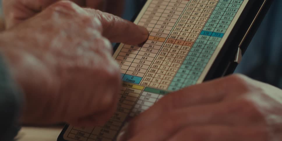 Fingers of an elderly person on a table with data