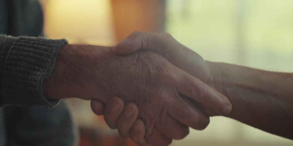 A handshake is shown between two men in agreement