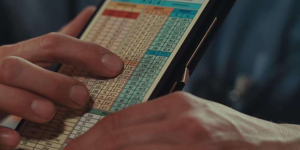 Pair of hands of a nurse showing a notebook with numbers