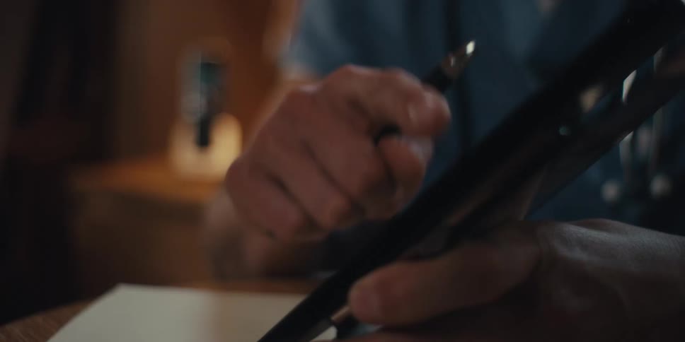 A male nurse is talking to someone in front of him while pointing his finger at a tablet