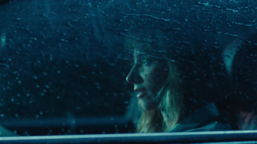 Woman inside a car at night in the rain