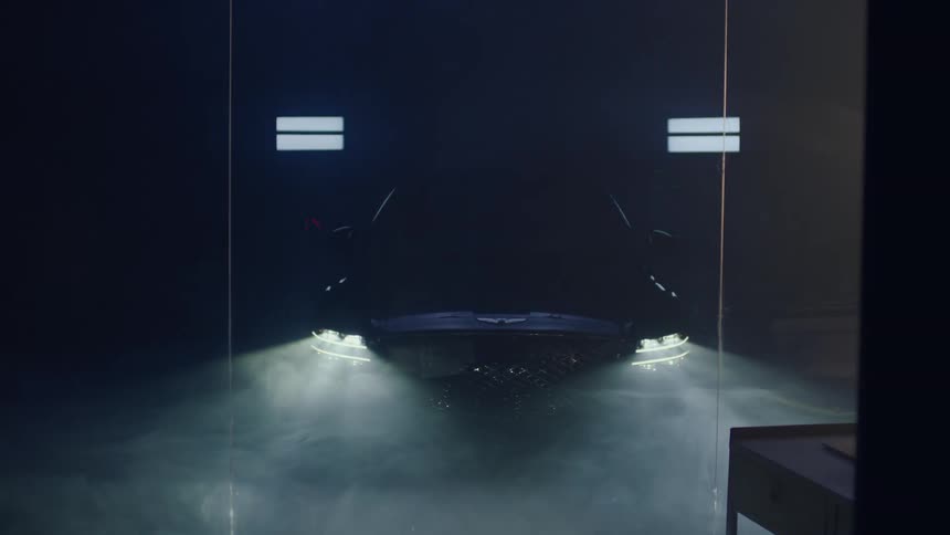 A footage of a man standing beside a car in a showroom