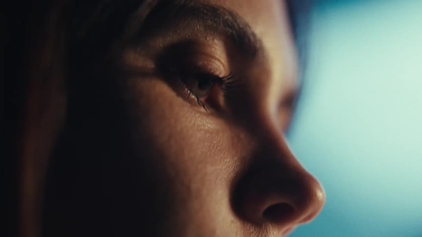 Side closeup of a womans face in an indoor setting