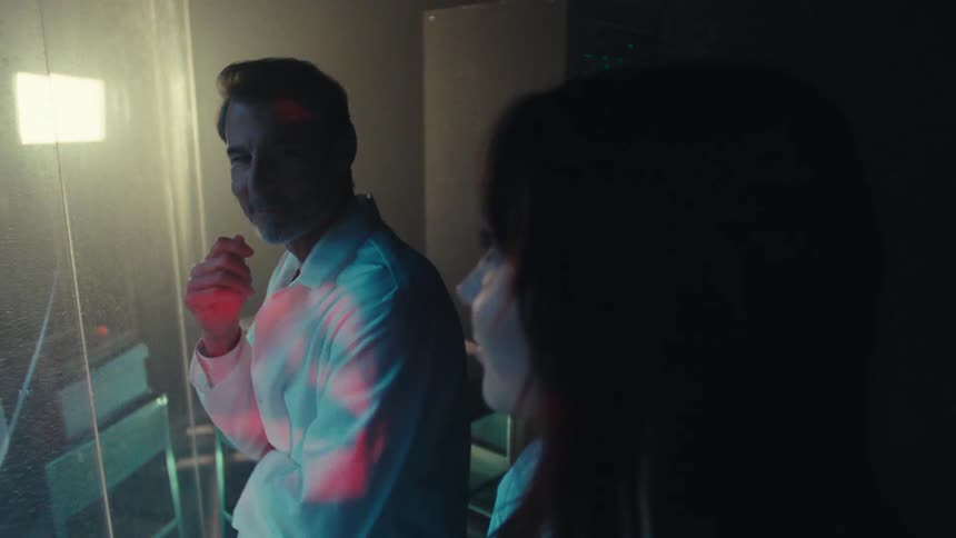 Woman and man in scientist lab coats looking at each other with happy expression