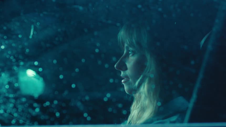 Woman inside a car watching the rain