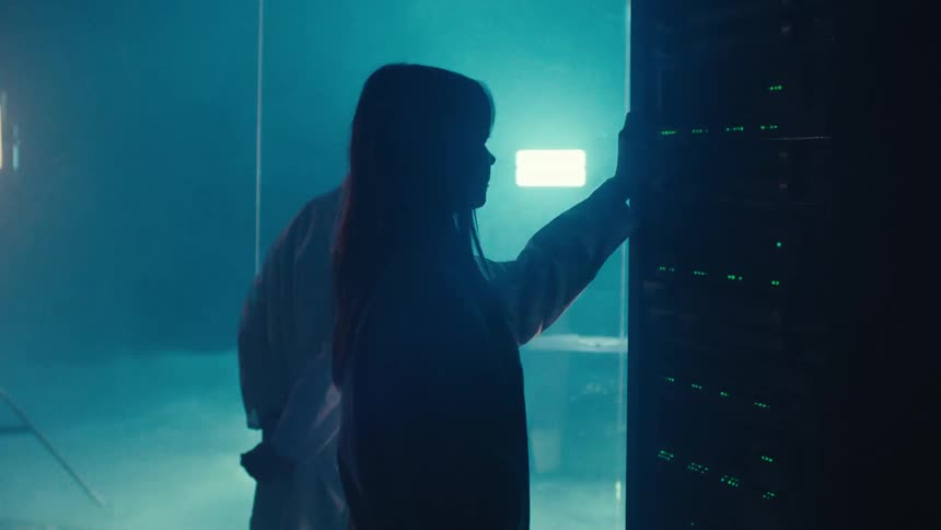 Silhouette of a woman and a man on a database inside a room with a car in the background