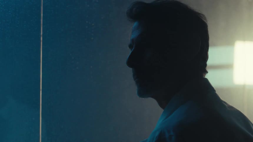 Silhouette of a man in a studio wearing a white lab coat