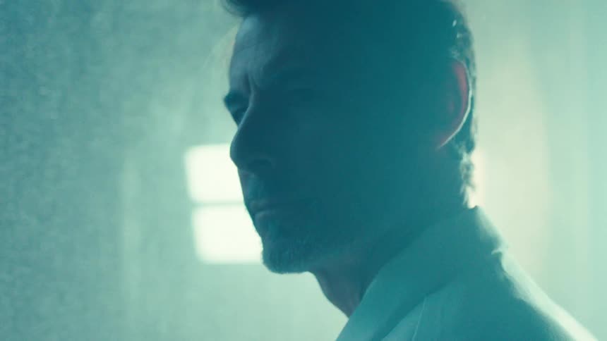 Man in lab coat in an indoor space with flashing lights