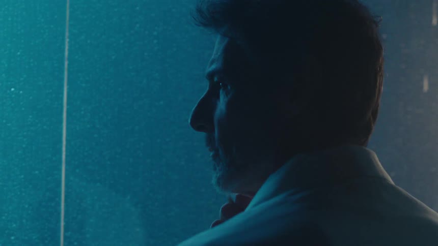 A man watches the rain at night