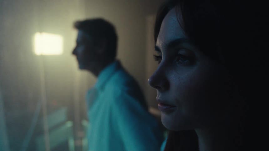 Woman and a man in a white coat observing an experiment