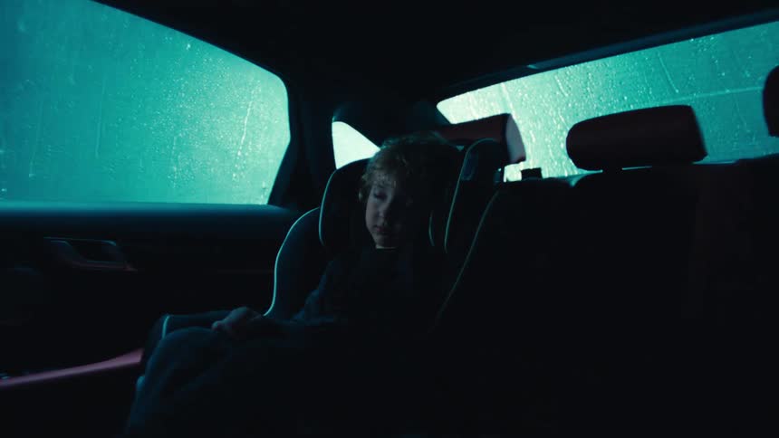 Child sleeping in car seat as car goes through the car wash