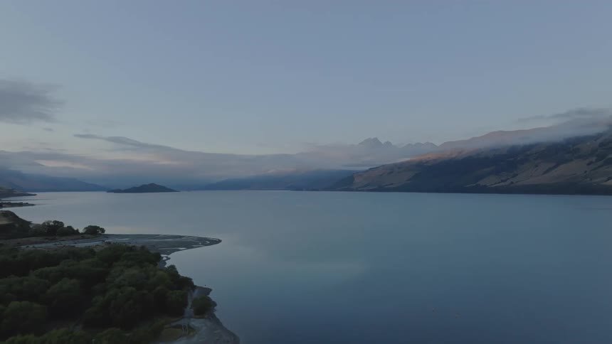 Aerial landscape at dawn of a calm lake surrounded by mountains