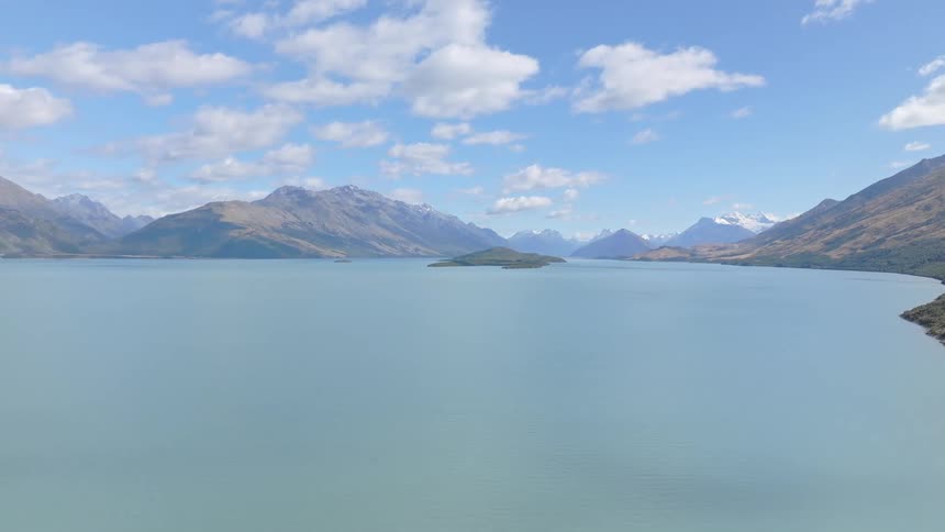 The lake water is calm between the two mountain ranges