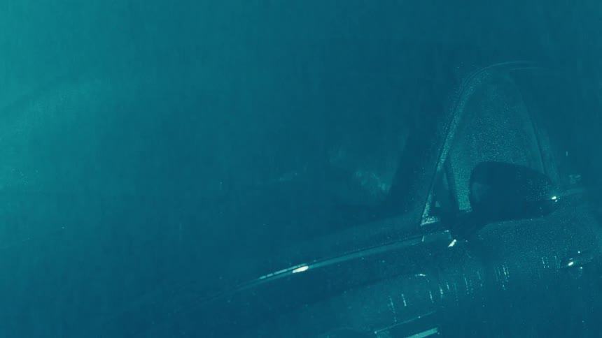 Heavy rain falling on a parked car