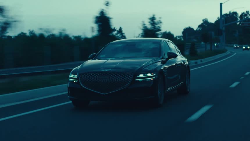 Car is one of several vehicles driving along a highway after dusk