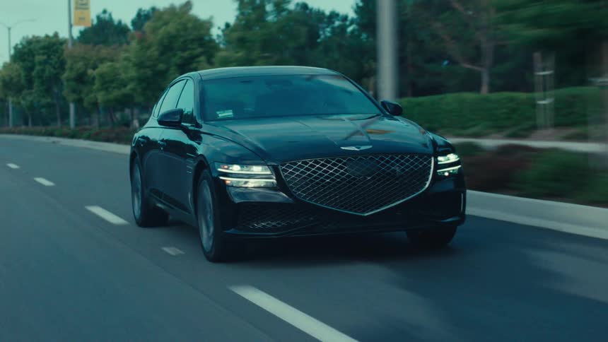 A nice car is driving down a road in the exterior or a town
