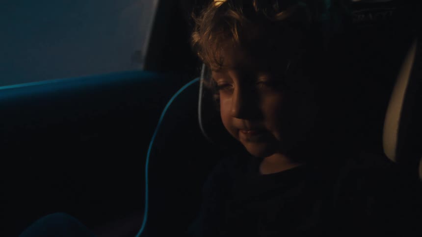 The child is sleeping as the car travels