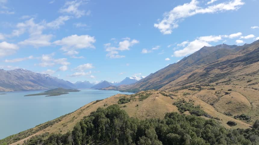 A forest is growing in only small areas of a mountain range near a lake