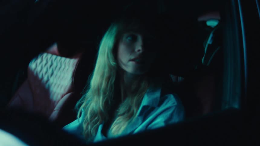 Mother inside a car and her little daughter sleeping in the back seat