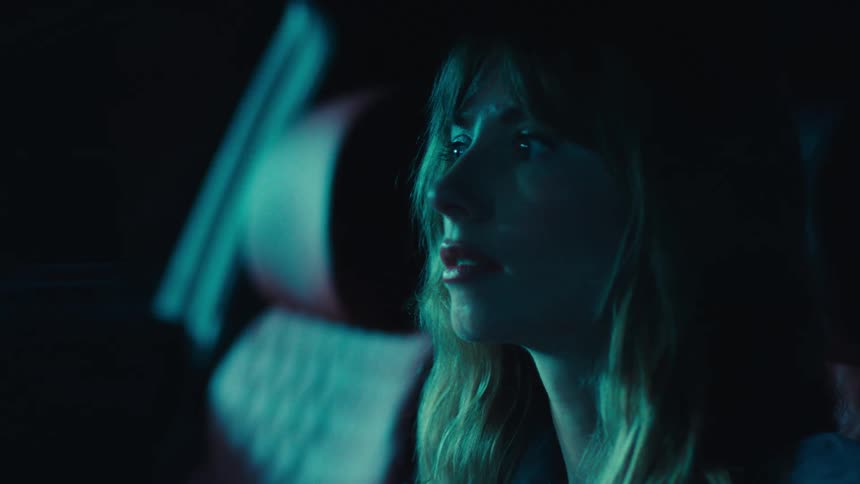 Blonde woman inside a car at night
