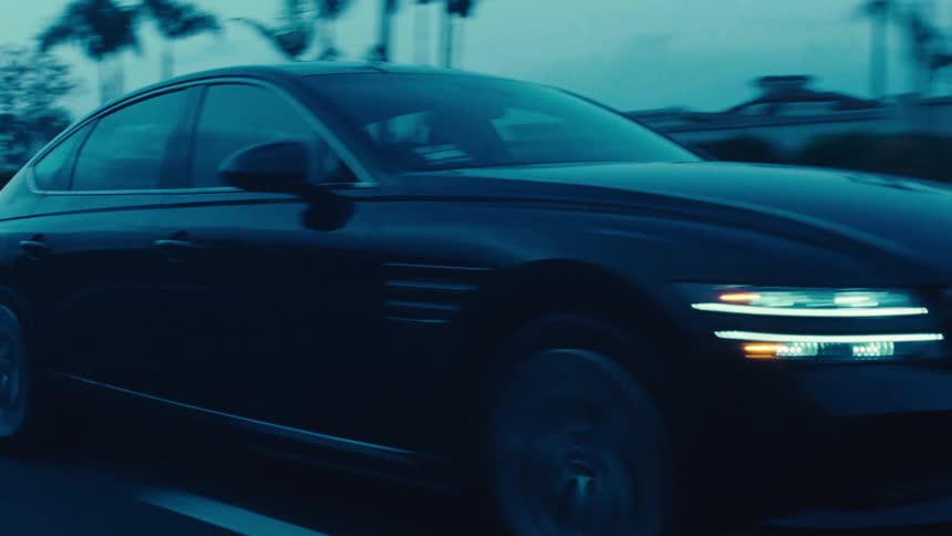 Black sedan car changing lanes on the highway after using its turn signal