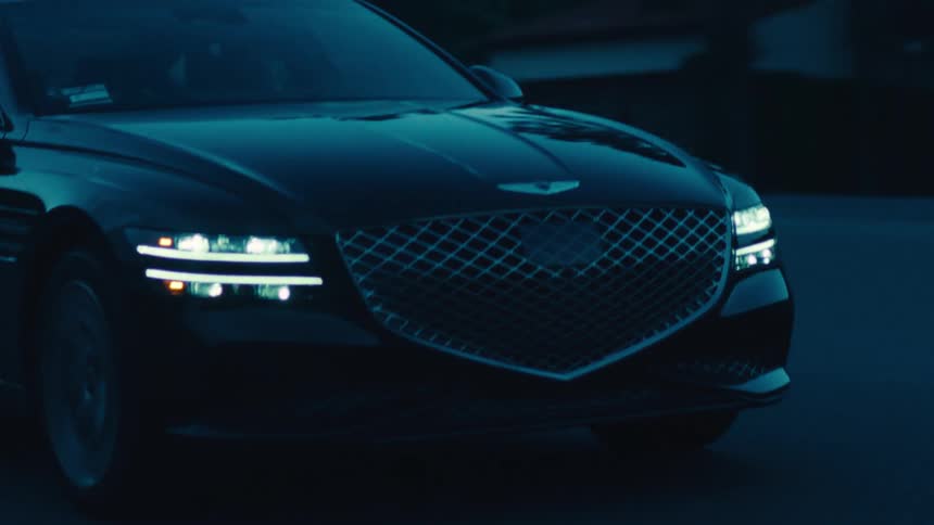 A car is driving down a road during the night time