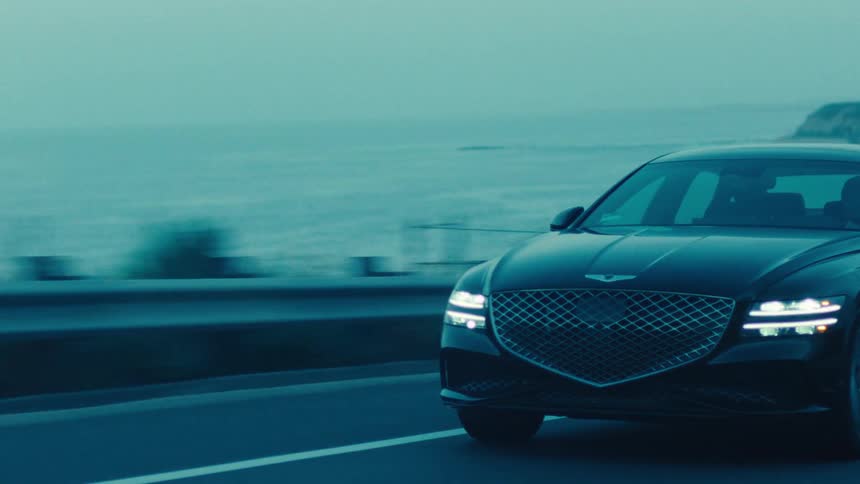 A car drives past the foggy shore