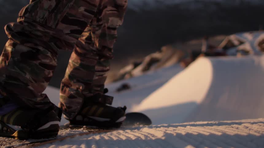 Close up of a snowboarder going down a hill