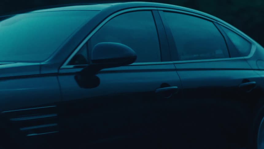 Black sedan car traveling down a road
