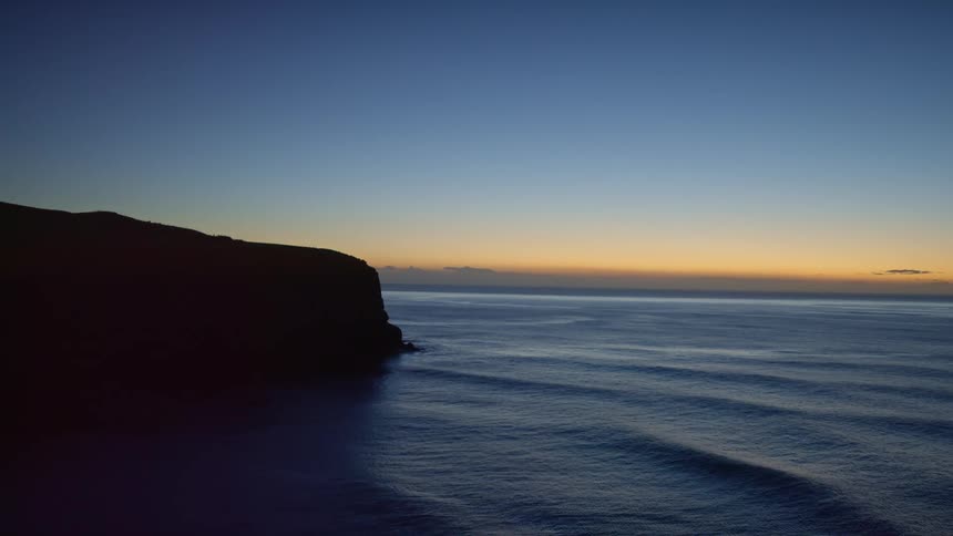 Panorama of a calm sea at dawn with the orange sky on the horizon