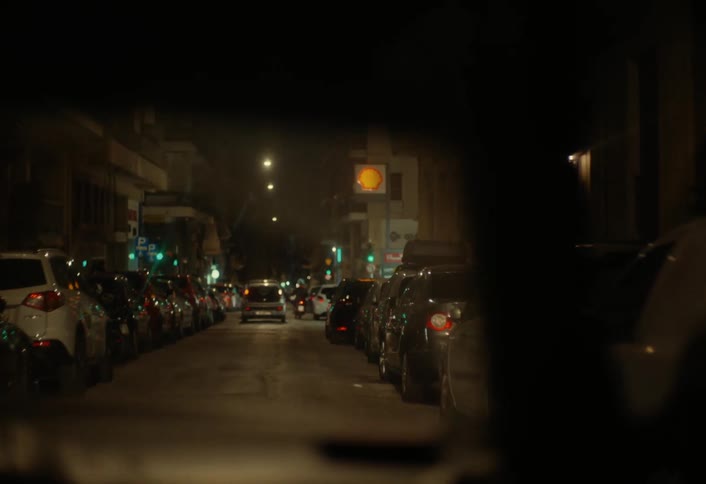 Vehicle travels along busy city streets at night