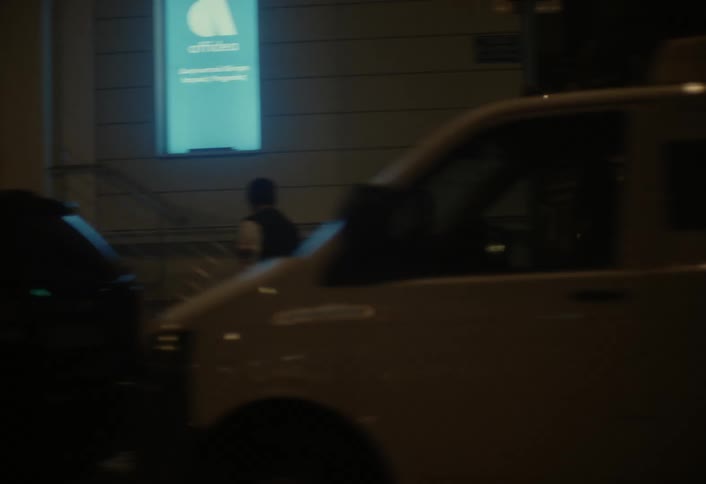 People are walking on the sidewalk at night in the city