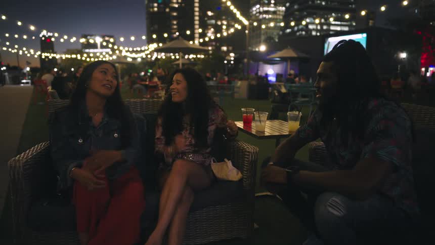 Friends are having drinks and talking at the outdoor club